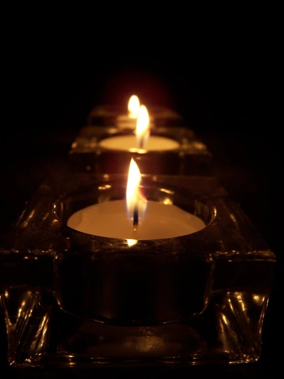 a row of candles with one lit up in the middle