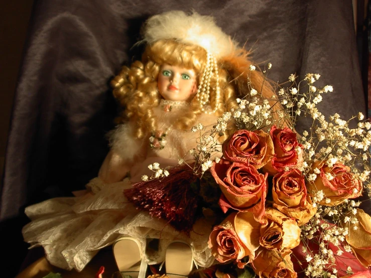 doll next to bunch of flowers in decorated vase