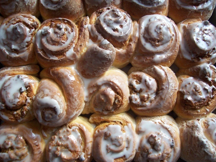 cinnamon rolls with icing sitting in a tray