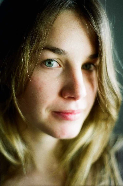 a woman wearing a collared blouse and looking directly at the camera