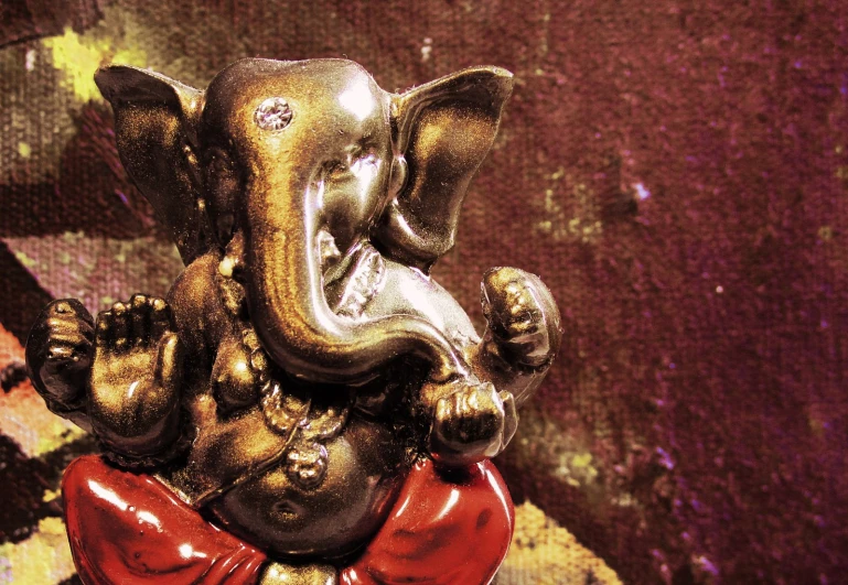 the small statue of an elephant in a red bow tie