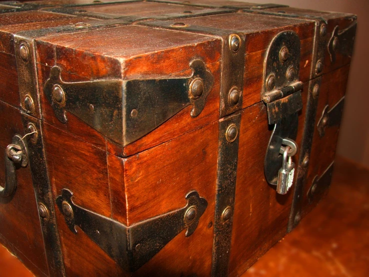 a wooden trunk sits on a table and has latches on it