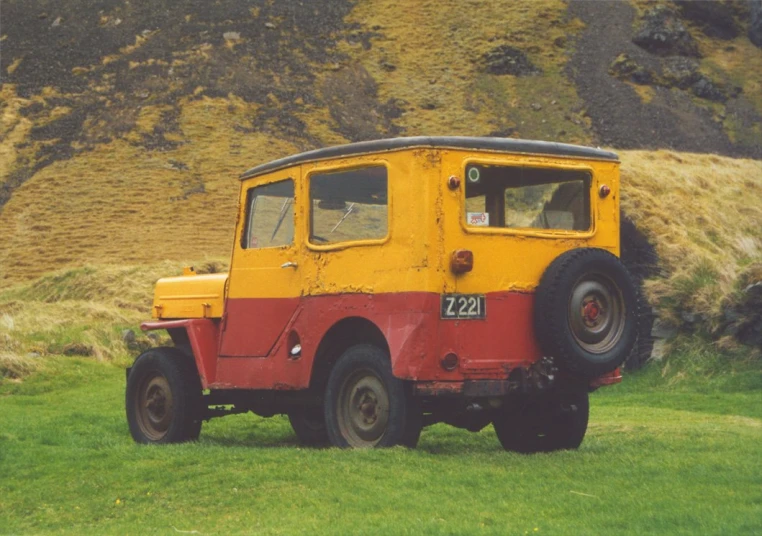 an old vehicle that is sitting in the grass