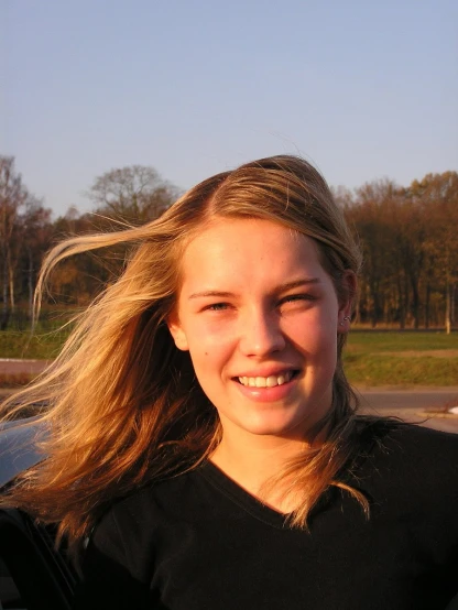a young woman posing outside and smiling for the camera