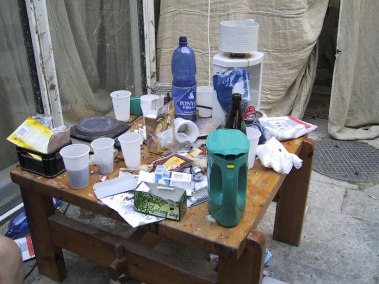 a table with bottles, bowls, scissors and other items on it