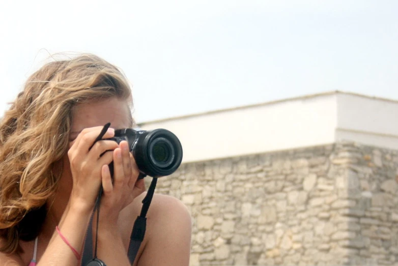 a beautiful young lady taking a po with a camera