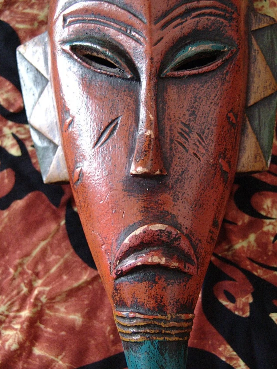 an old tribal mask on a patterned cloth