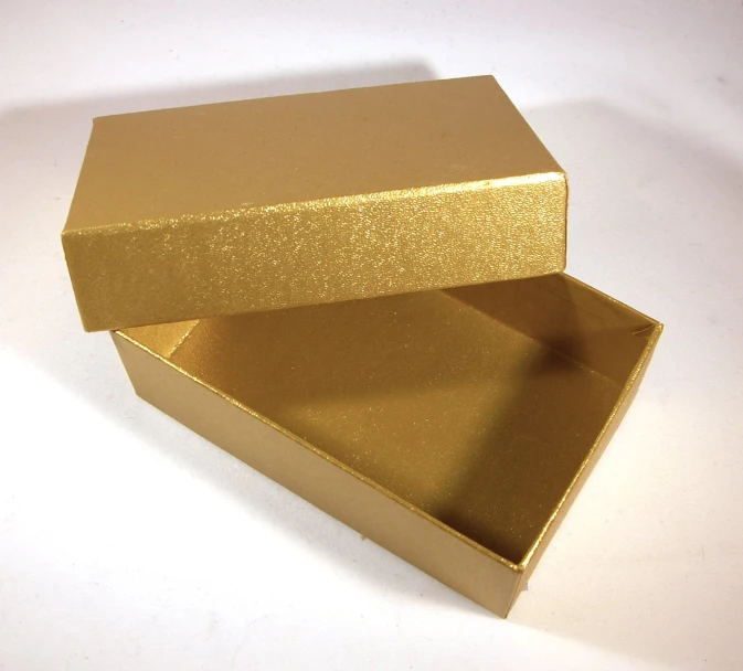 two gold colored boxes on a white surface