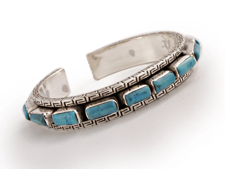 a silver cuff with blue stones and an intricate design