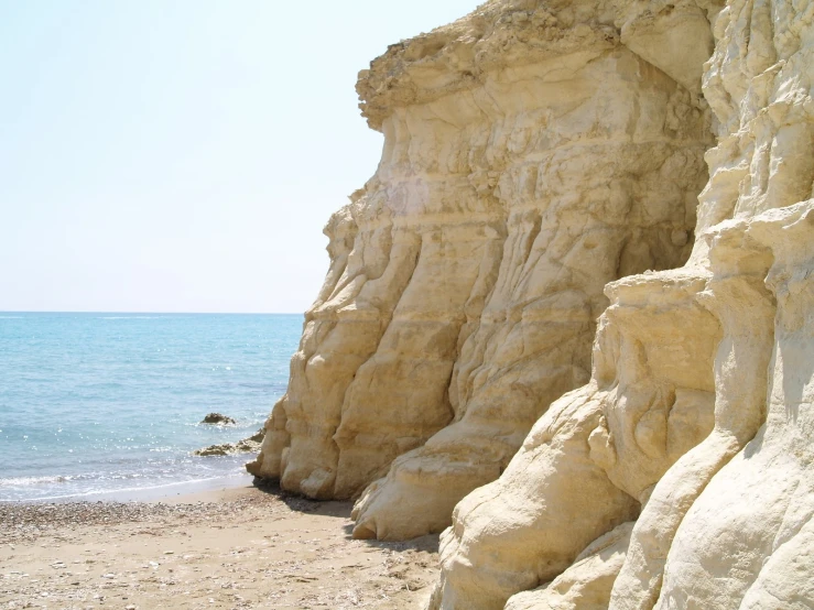 a rocky hillside by the ocean in a sunny day