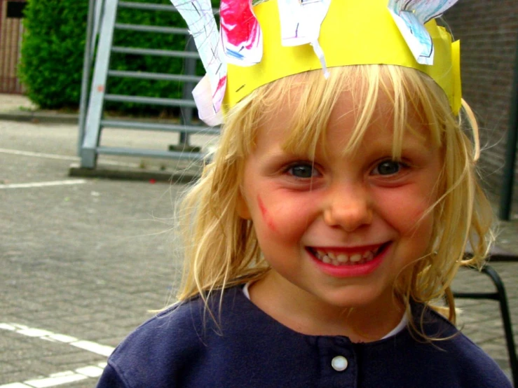 a little girl with a paper crown on her head