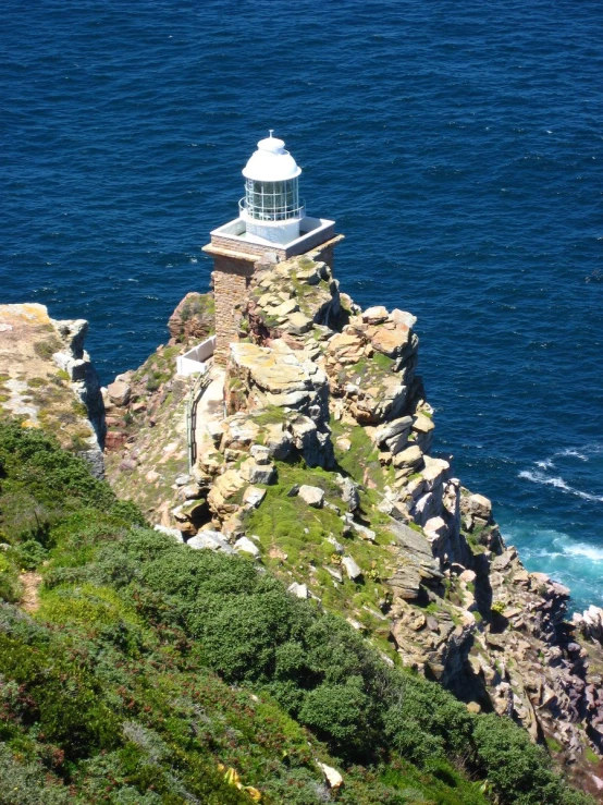 the light house overlooks the ocean and rocks