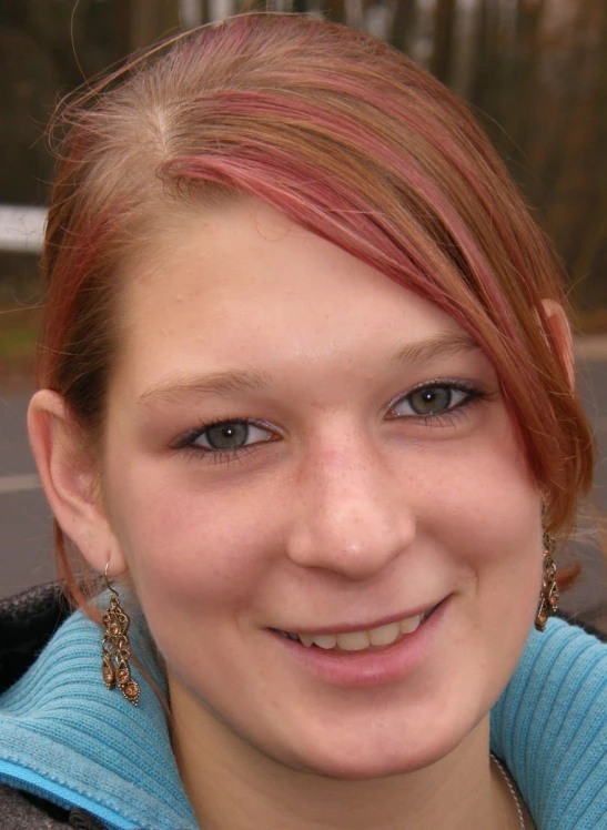 a girl with bright red hair holding a cell phone