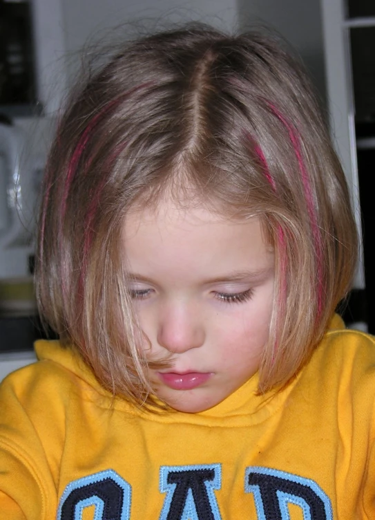 the little girl is staring at the food in her hand