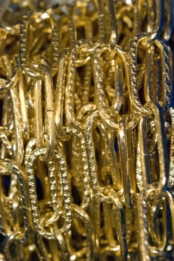 many gold chains are stacked together in a large area