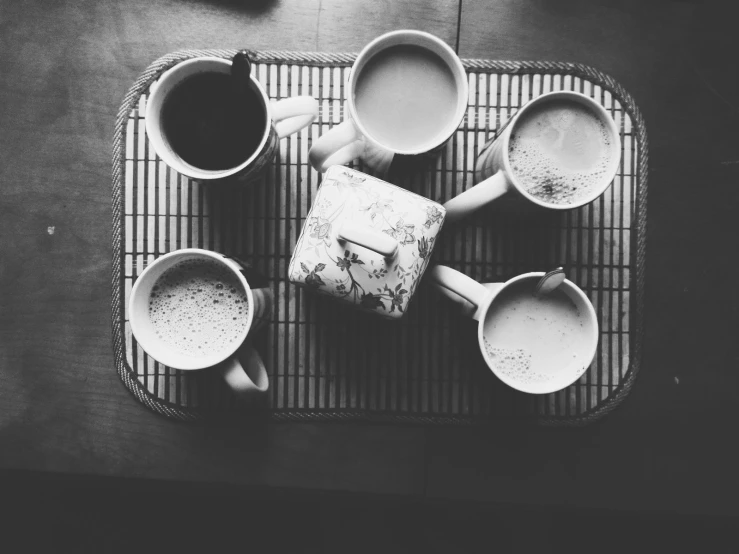 black and white pograph of coffee mugs on a woven placemat