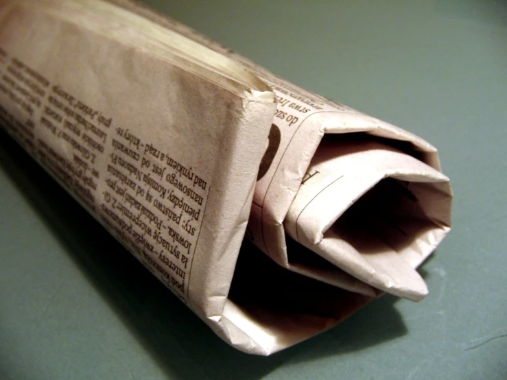 folded newspaper laying on table showing wording inside