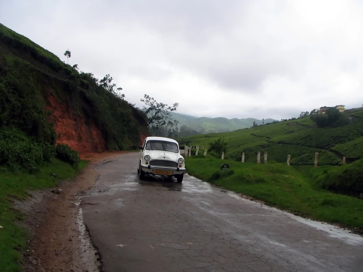 a van driving on a road in front of a hill