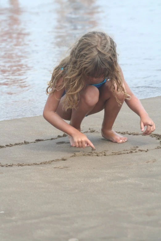  in bikini writing in the sand
