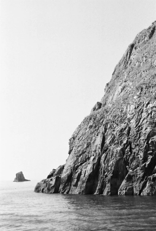 a black and white po of a cliff next to the ocean