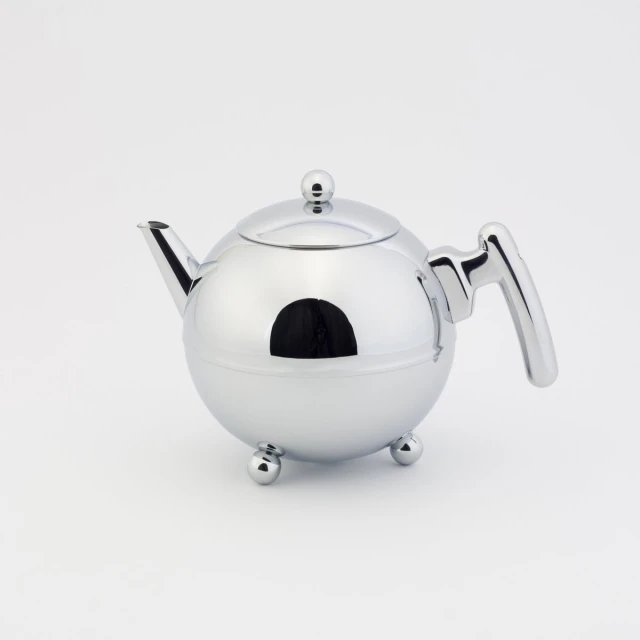 silver tea pot with a lid sitting on top of it