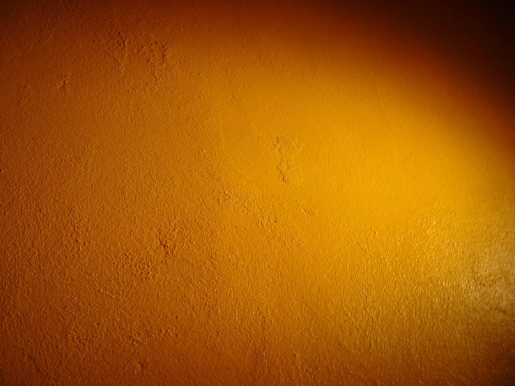 a light colored orange wall with a yellow and white light