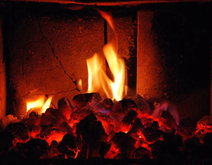 fire burning in fireplace with rocks and logs