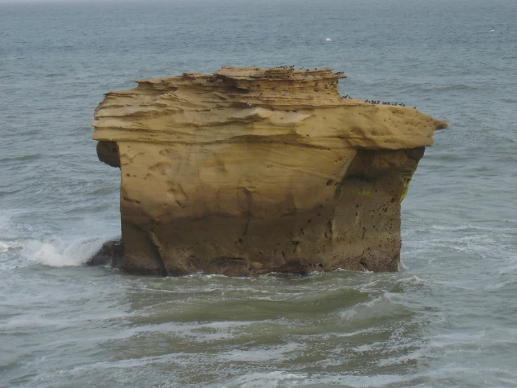 the rocks in the ocean are eroded to make a large island