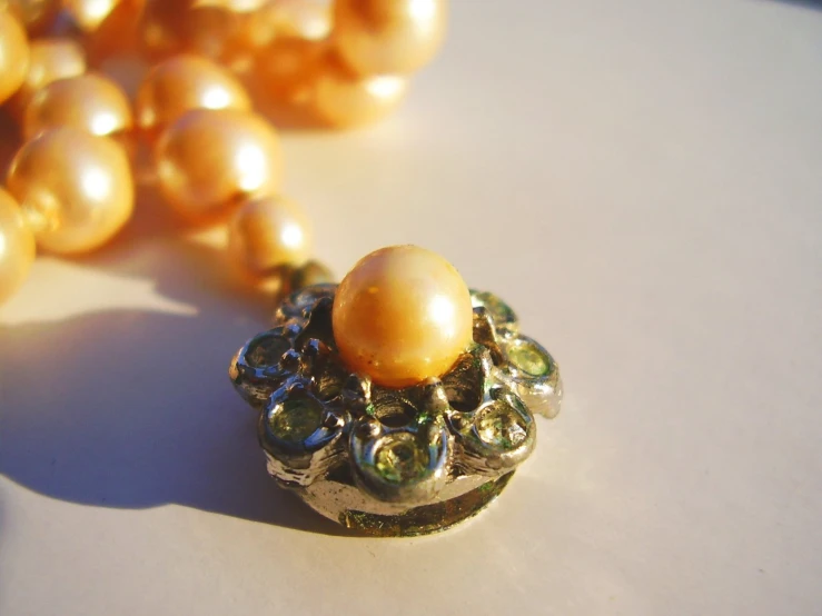 a close up of a necklace with pearls