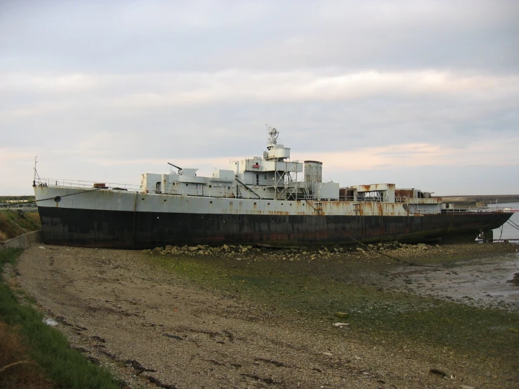 an old ship lying on the shore of a beach