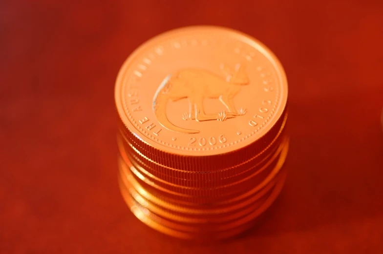 a stack of golden round coins sitting on top of a table