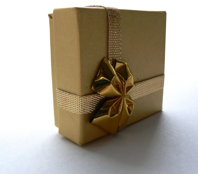 a present with gold ribbons wrapped in brown paper