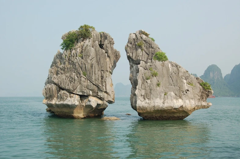 two large rocks in the water next to each other