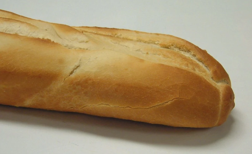 a long loaf of bread sitting on a white counter
