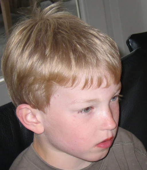a child is sitting in an office chair with a concerned look on his face