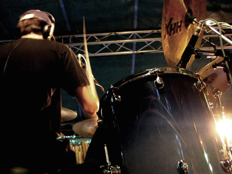 man playing drums in the dark at night