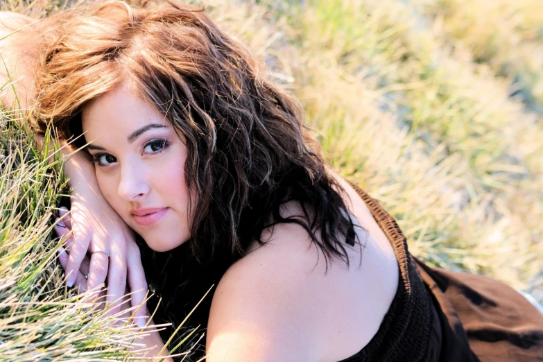 a woman laying down in a field of grass