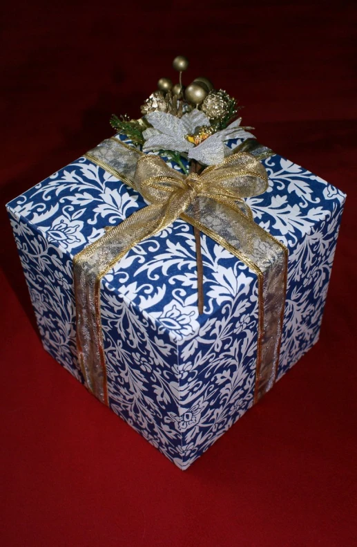 this is a gift wrapped in blue and gold paper with gold ribbons