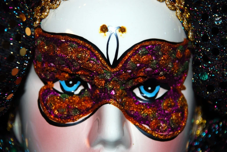 a woman with blue eyes wears a fancy mask