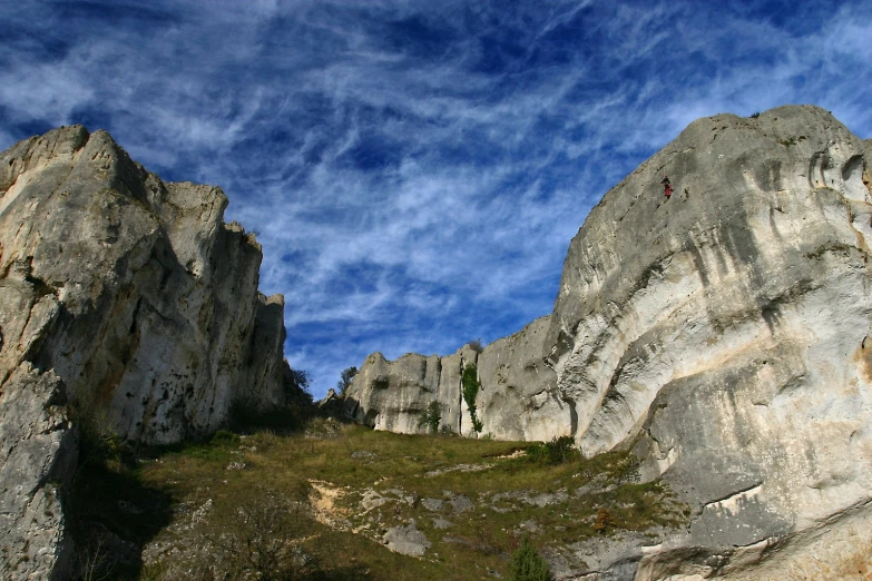 a couple people walk up some steep steps between two large rocks