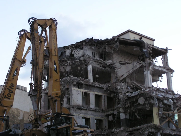 a large construction truck and a small bulldozer near a building