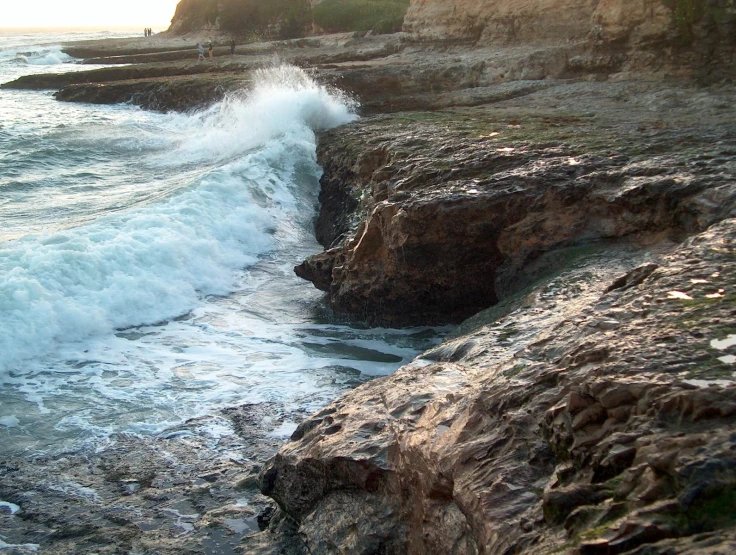 the ocean splashes on the rocky shore