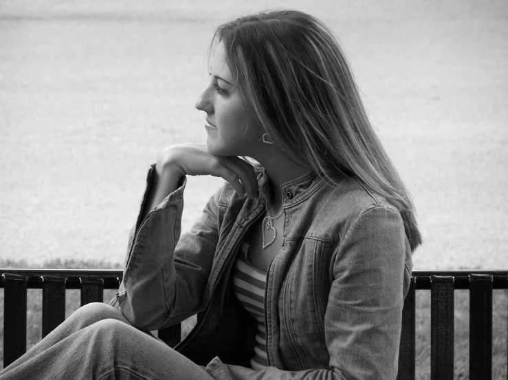 a woman is sitting down near water and railing