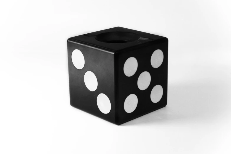 a black dice with white polka dots on it