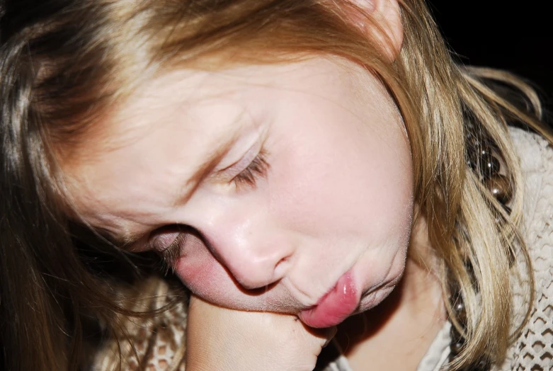 a close - up s of a little girl sticking her tongue out