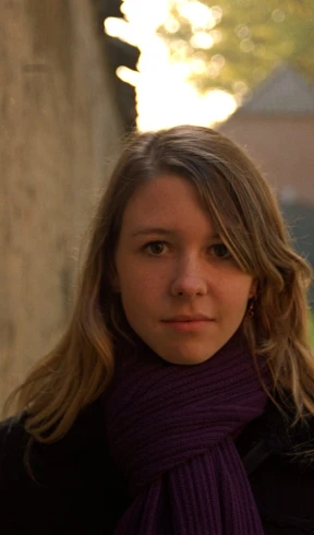 a woman with a purple scarf and black jacket
