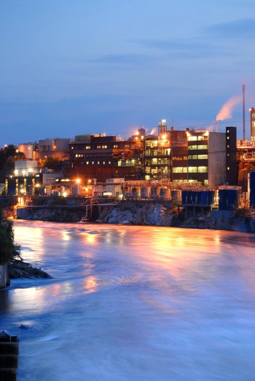 an industrial town near a river at night