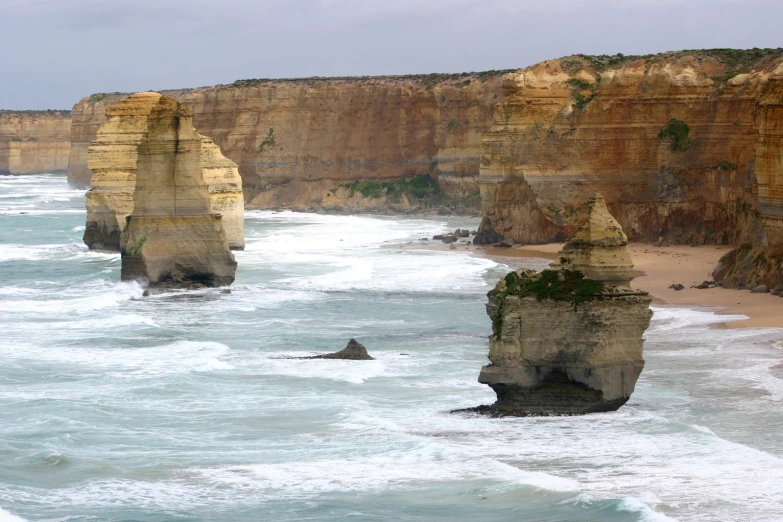 the ocean next to cliffs and an empty beach