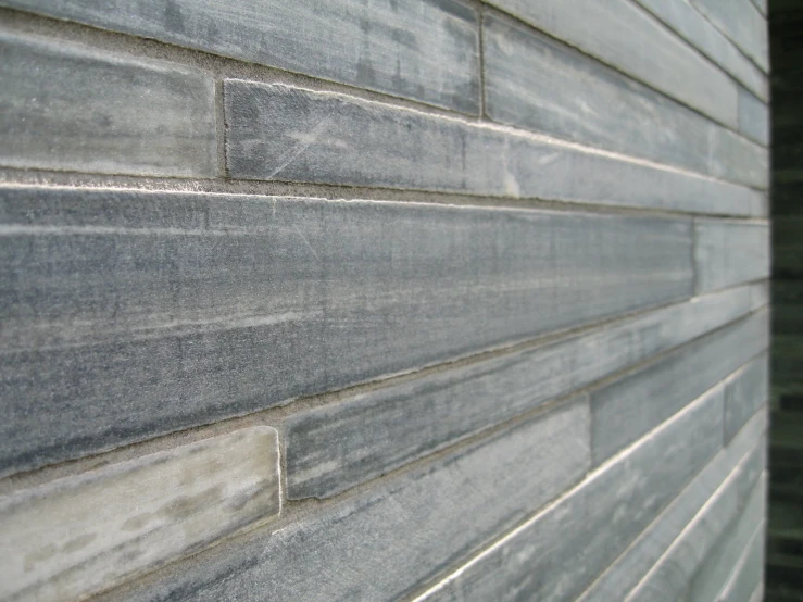 the front side of a stone building that has grey colored tiles