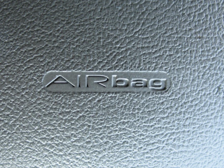 the back end of an airplane seat with a small metal emblem